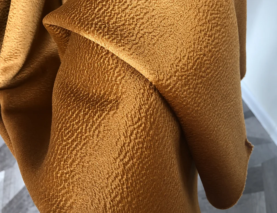 Brown textured fabric draped into soft folds