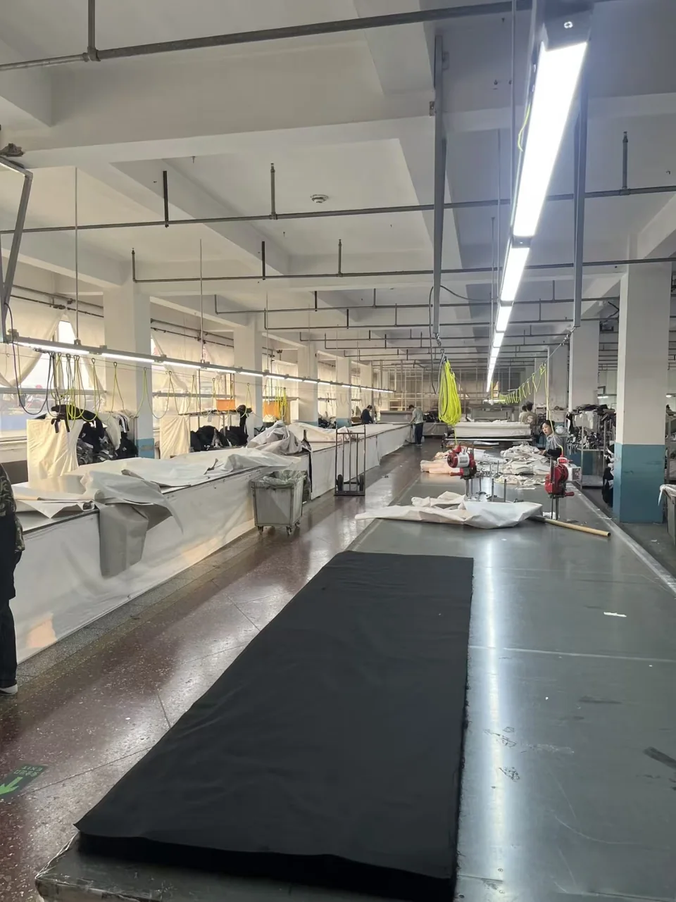 A length of dark fabric laid flat on a long preparation table