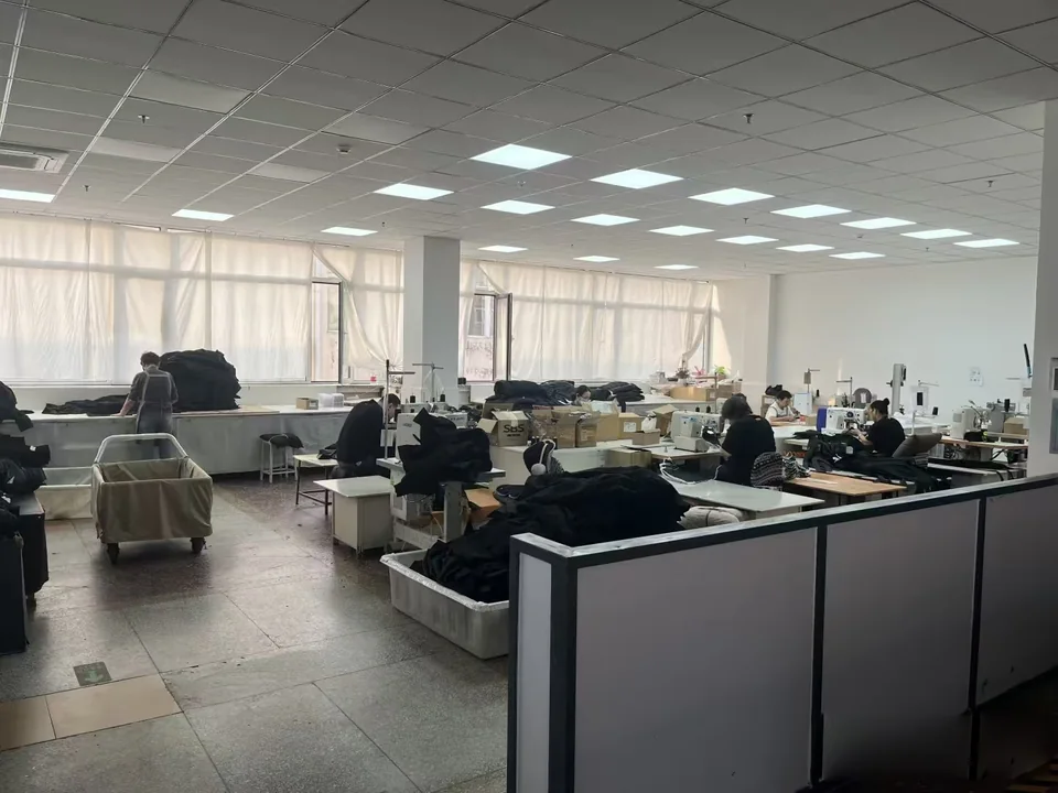 A wide view of a garment workspace with worktables and sewing stations